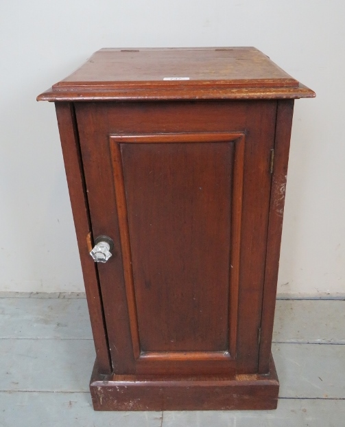 A 19th century mahogany pot cupboard, with a lift up top, over a single cabinet door,