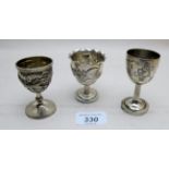 Three Chinese white metal egg cups, two