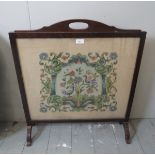 A mid 20th century oak fire screen with