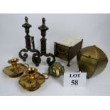 A pair of cast iron fire dogs, a pair of brass chamber sticks, a cast brass rams mask applique,