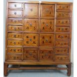 A 20th Century Chinese set of hardwood medicine drawers with twenty four drawers each bearing