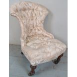 A pretty Victorian child's nursing chair upholstered in cream buttoned material and terminating on