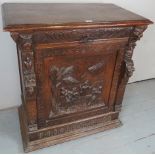 A Victorian heavily carved oak cabinet with a long drawer to top over a moulded figural panel to