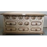 A small rustic white painted table top apothecary cabinet with thirteen drawers and painted gilt