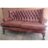 A fine quality period-style 20th Century brown leather high back sofa with deep buttoned back,