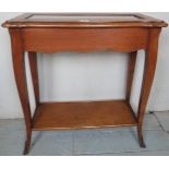 A 20th Century mahogany side table with a shaped top with inset glass to centre over a lower shelf