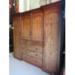 An impressive Victorian pale mahogany reverse break front triple wardrobe compactum with central