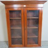 An Edwardian mahogany and inlaid wall hanging display cabinet with double glazed doors and three