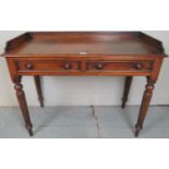 A Victorian mahogany table / desk with a raised gallery rail over two frieze drawers and turned