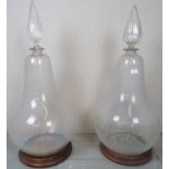 A large pair of glass bulbous chemist bottles each with decorative cut glass stoppers and complete