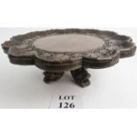 A large revolving stand or Lazy Susan of Chinese design with four dragon feet and foliate carved