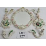 A continental porcelain mirror and two wall mounted cherubs of similar design and four candle arm,