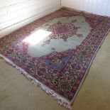 A late 20th century wool carpet on pale green ground and in good condition,