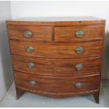 A George III mahogany bow fronted chest of two short over three long drawers with oval brass