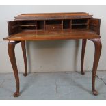 An early 20th Century piano top secretaire with a fitted interior over cabriole legs and with a