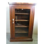 A late 19th Century walnut music cabinet with a glazed door,