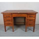 A C1930's oak and pine office desk with a central frieze drawer flanked either side by three