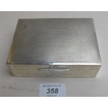 A silver cigarette box with engine turne