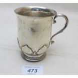 A heavy silver christening mug with over