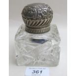 A cut glass inkwell with silver embossed