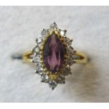 A marquise cut dress ring with purple ce