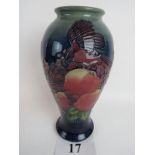 A modern Moorcroft pottery vase, decorated with birds and fruits on a blue ground,