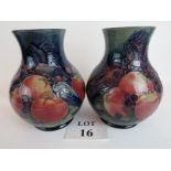 A pair of modern Moorcroft pottery vases, decorated with birds and fruits on blue grounds,