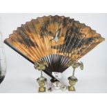 A large decorative fan, a pair of decorative gilt-metal 'palm tree' candle holders,