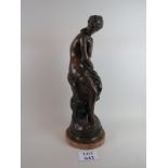 A bronze statue of a woman in the classical style, on a marble base,