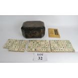 An ivory faced Mahjong set with bamboo backing circa 1900 in an lacquered box, slightly a/f,