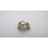 A 14ct white and yellow gold ring, inset with centre pearl and ten baguette cut diamond shoulders,