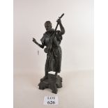 A cast bronze statue depicting a musician in Arab dress playing a string instrument, well patinated,