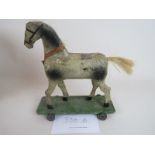 A late 19th/early 20th century child's pull-along wooden toy horse, platform base, wheels,