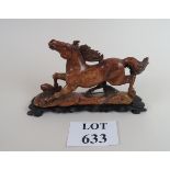 A Chinese carving of a horse in stone, on fitted wooden stand,