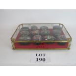 A set of twelve clockwork music boxes in a dedicated glass display case, one lid missing,