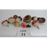 A collection of antique wooden spinning tops in vibrant colours, some with a double spin action,