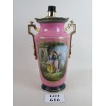 A porcelain vase converted to a lamp base in pink ground and a cartouche showing a courting couple,