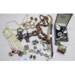 An assortment of costume jewellery to include a 9ct gold engraved crucifix, a cameo brooch,