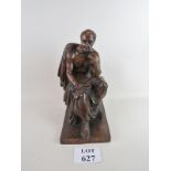 A solid wooden carved statue of a seated gentleman in Roman style dress,