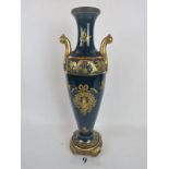 A large ceramic amphora vase with lavish gilt decoration on a blue ground, applied gilt-metal base,
