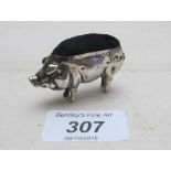 A silver pig pin cushion,