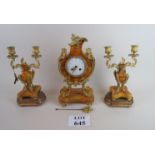 A clock garniture in striking orange marble with ormolu mounts, both candelabra with wooden mounts,