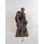 A solid wooden carved statue of a seated