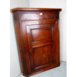 A George III oak corner cupboard with an