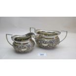 A heavily embossed silver cream jug and