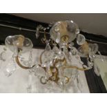 Four brass wall light fittings with cut glass drops and glass sconces around the bulb fitting,