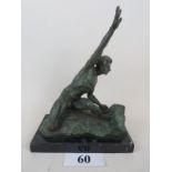 A signed contemporary bronze sculpture depicting a naked male figure in artistic pose on rocks,