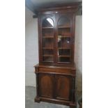 A Victorian mahogany bookcase in very good condition and with arched glazed doors over a blind