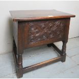 A small 20th Century carved oak work table with a lift up lif over a carved panel and lower