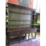 A fine Georgian oak high back dresser with a plate rack to top over three drawers and pot board